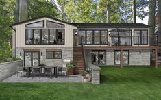 this is an artist's rendering of a modern house in the woods with stone and wood accents