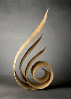 an abstract sculpture made out of cardboard on a gray background with the shape shaped like a spiral