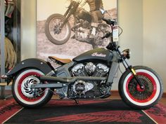 a motorcycle parked in front of a poster on the wall next to a carpeted floor