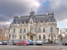 cars parked in front of a large white building