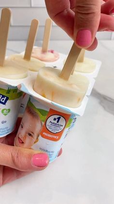 two popsicles with toothpicks in them being held by someone's hand