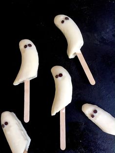 four marshmallows shaped like ghost faces on sticks