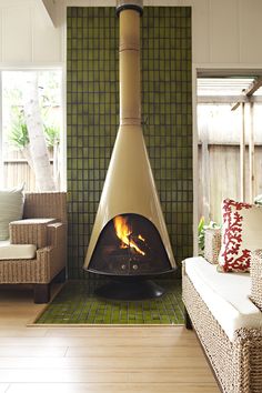 a living room filled with furniture and a fire place in the middle of it's fireplace