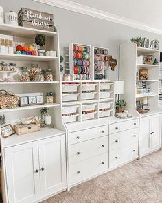 a room filled with lots of white cabinets and shelves covered in crafting supplies on top of carpeted floors