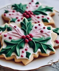 decorated cookies on a plate with holly decorations