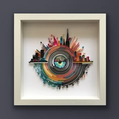 an art piece in a white frame with cityscape on the wall behind it