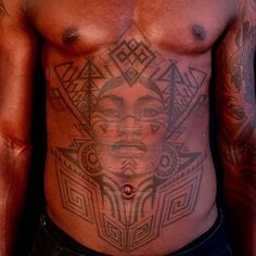 a shirtless man with tattoos on his chest