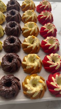 there are many different types of doughnuts on the tray together, including one with white frosting