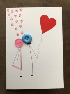 a card with two buttons attached to the back of it, and a heart shaped balloon