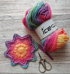 two balls of yarn are next to each other on a wooden surface with scissors and crochet hooks