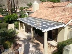 an aerial view of a house with a solar panel on the roof and patio area