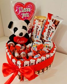 a valentine's day gift basket with chocolates, candy and a stuffed panda bear