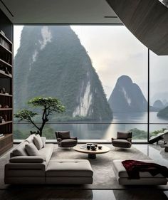 a living room filled with furniture next to a large window covered in mountain view over water