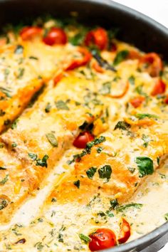 an omelet with cheese, tomatoes and spinach on top is shown in a pan