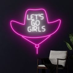 a neon sign that says let's go girls with a cowboy hat on it