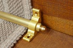 a close up of a metal door handle on a wooden door with a knitted blanket behind it