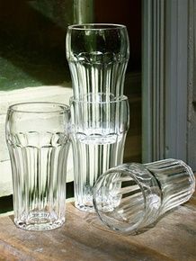 three clear glass vases sitting on top of a wooden table next to each other