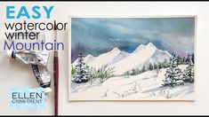 an easy watercolor winter mountain scene is displayed on the wall next to some scissors