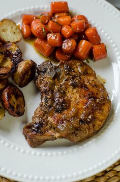 a white plate topped with meat, potatoes and carrots