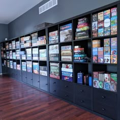 a large book case filled with lots of books on top of a hard wood floor