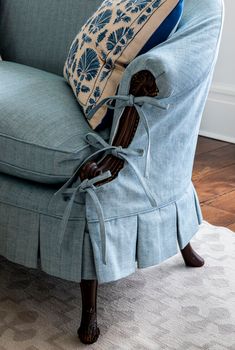 an upholstered chair with blue and white pillows