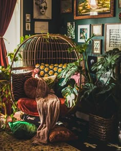 a bird cage sitting on top of a couch next to potted plants in a living room