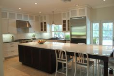 a kitchen with an island and chairs in it