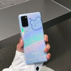 a person holding up a phone case with an image of a teddy bear on it