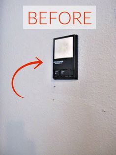 a cell phone mounted to the side of a wall with an arrow pointing towards it