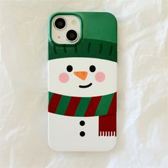 a phone case with a snowman on it sitting on top of a white sheet