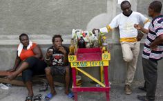 four people sitting on a bench near a wall