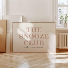 the snooze club sign in front of an empty room with wooden floors