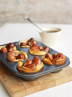 a muffin tin filled with mini pigs in a blanket next to a cup of milk