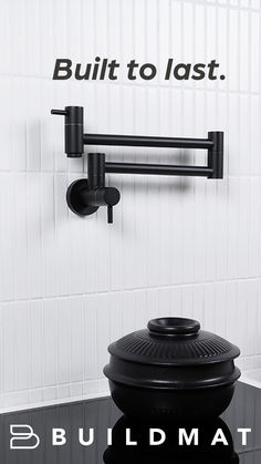 Matte black wall mounted pot filler rests flush against the stovetop wall. It resembles the structure of a desk lamp in the way it angles and folds against itself. Below it is a kitschy-looking matte black soup pot on a large black induction stove. Pot Fillers, Kitchen Interiors, Pot Filler