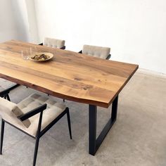 a wooden table with two chairs and a bowl of food on it's side