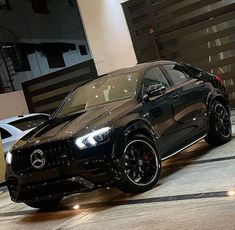 a black mercedes suv parked in front of a building