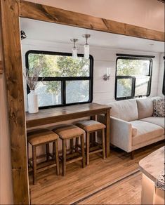 a living area with couch, table and chairs in a mobile home that is built into the side of a house