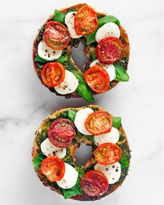 two open faced sandwiches with tomatoes, mozzarella and spinach