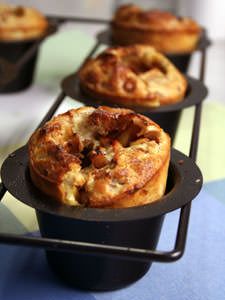 several different types of pastries in black trays on a blue and green tablecloth