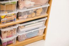 a wooden shelf filled with plastic containers and toys