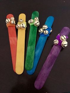 four different colored skateboards with metal bells on them and one has a bell attached to it