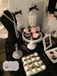 a table topped with cakes and cupcakes covered in frosting