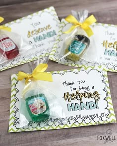 three hand sanitizers wrapped in cellophane and tied with yellow ribbon on wooden table