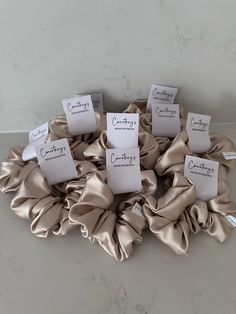 five scrunffles with name tags on them sitting on a marble counter top