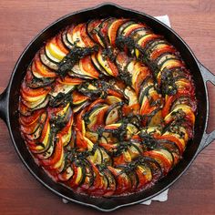 a pan filled with cooked vegetables on top of a wooden table