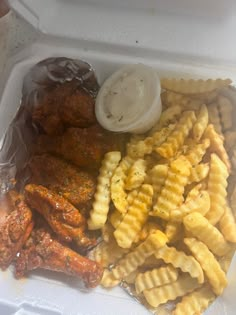 a plastic container filled with chicken wings and pasta