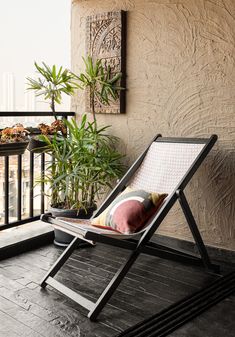 a chair sitting on top of a wooden floor next to a plant