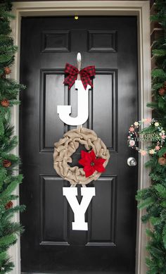 the front door is decorated for christmas with burlocks and poinsettis