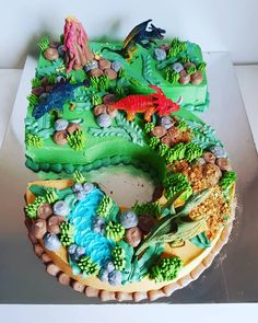 a cake decorated with animals and plants on a table