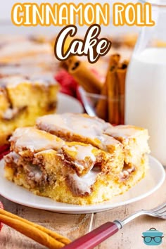 cinnamon roll cake on a white plate next to a glass of milk and cinnamon sticks